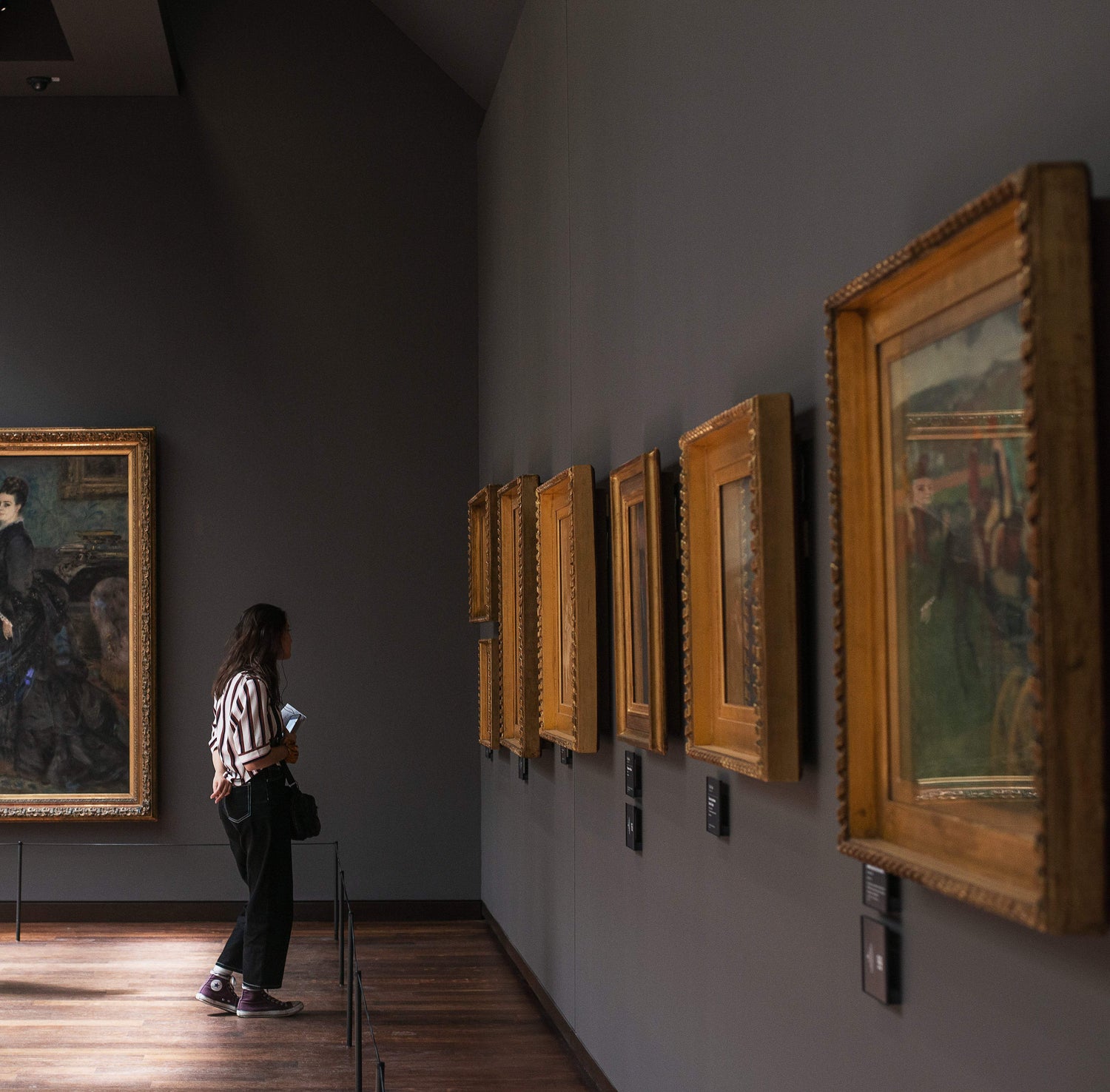 A-woman-stands-in-an-art-gallery-in-front-of-paintings_1-Wall Art - ArtPrintsS